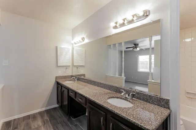 a bathroom with a granite countertop sink a toilet and mirror