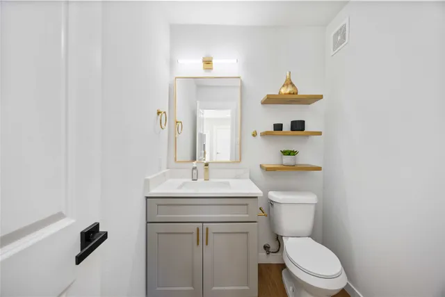 a bathroom with a sink a toilet and a mirror