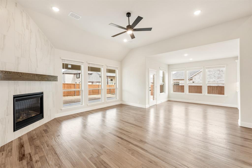 2304 Prosper Way Mansfield, TX 76063 - Photo 18 of 39 an empty room with wooden floor fireplace and windows