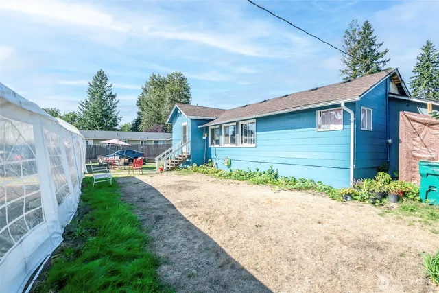 a front view of a house with a yard and potted plants