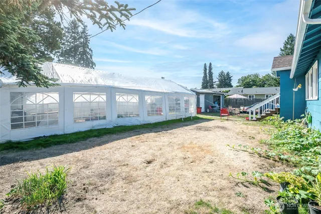 a front view of a house with a yard and potted plants