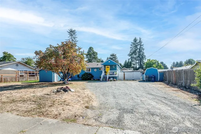 a front view of a house with a yard and trees