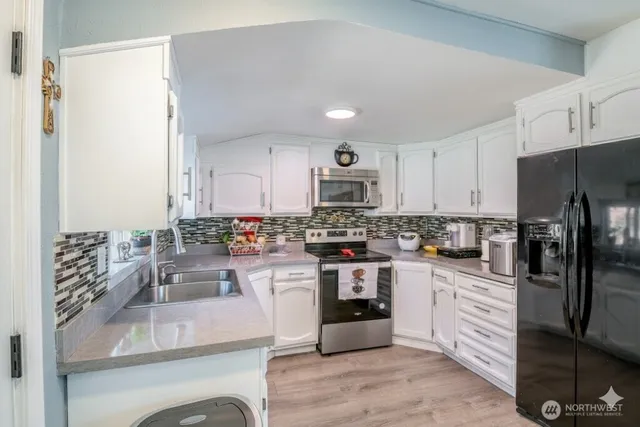 a kitchen with stainless steel appliances kitchen island granite countertop a refrigerator and stove