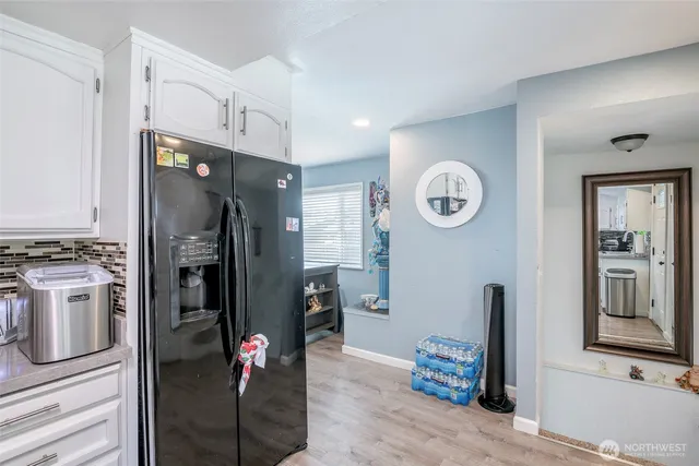 a view of a kitchen with fridge and wooden floor