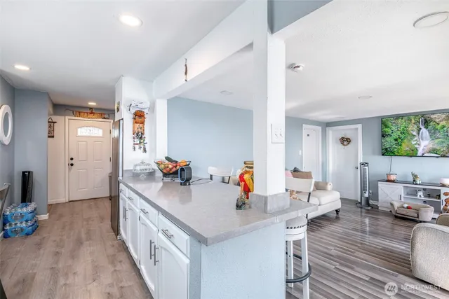 a kitchen that has a lot of cabinets a sink and a wooden floor
