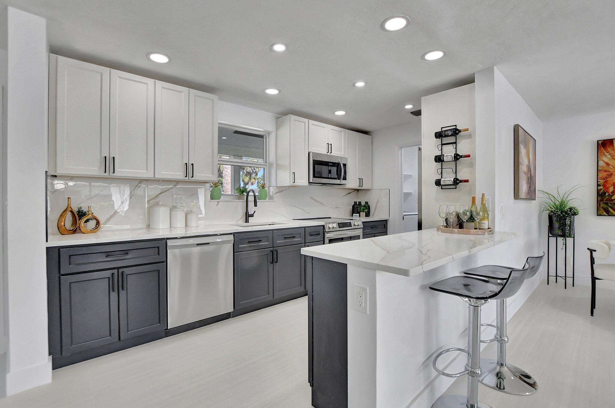 832 Southwest 10th Avenue Boca Raton, FL 33486 - Photo 9 of 57 a kitchen with kitchen island granite countertop a sink and cabinets