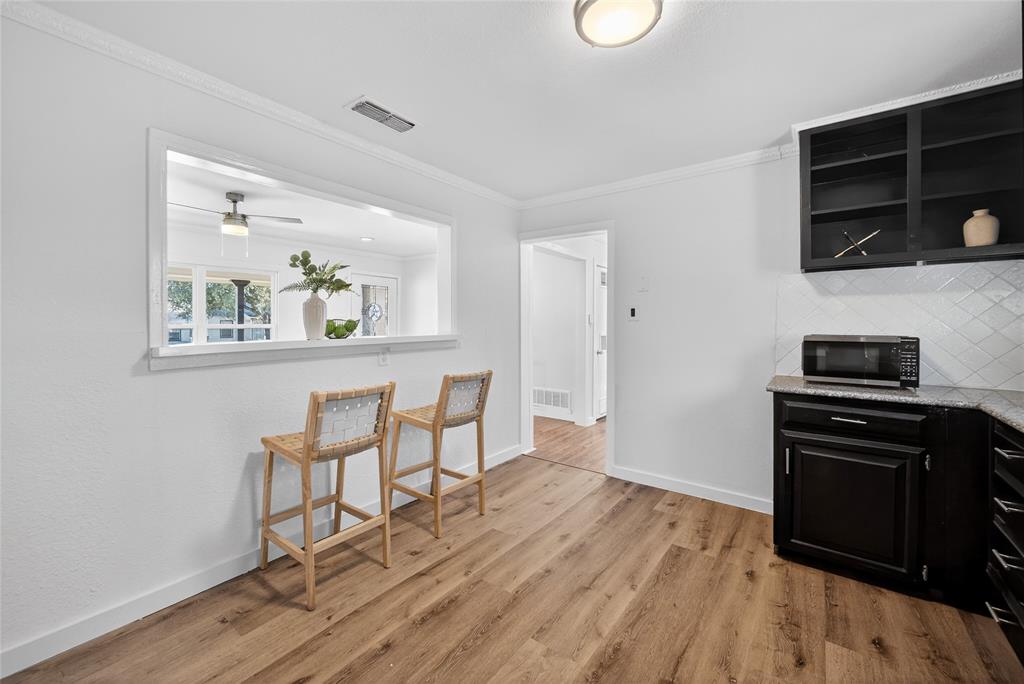 3417 Haltom Road Haltom City, TX 76117 - Photo 12 of 31 a kitchen with stainless steel appliances wooden floor and chairs