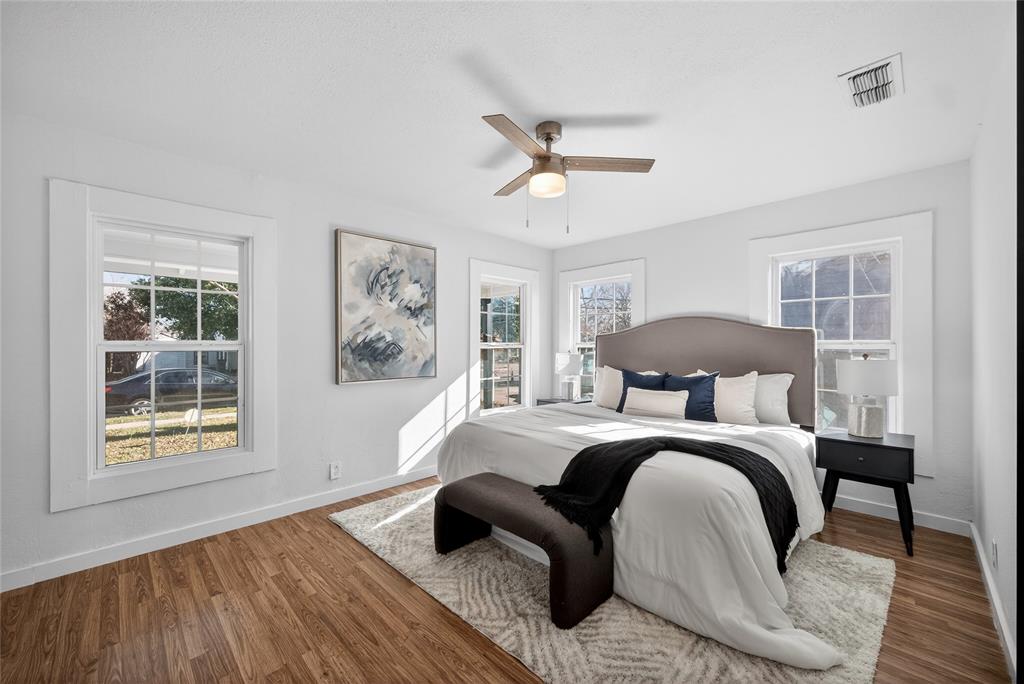 3417 Haltom Road Haltom City, TX 76117 - Photo 16 of 31 a bedroom with a bed and wooden floor