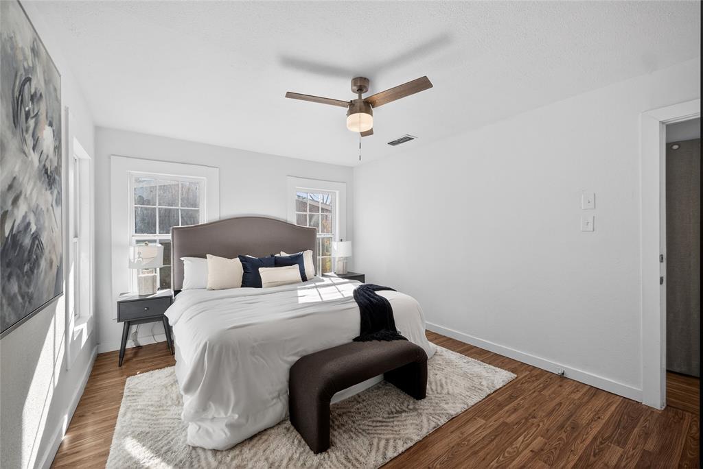 3417 Haltom Road Haltom City, TX 76117 - Photo 17 of 31 a bedroom with a bed and wooden floor