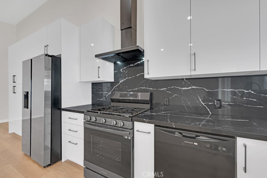 19104 Blackhawk Street Porter Ranch, CA 91326 - Photo 13 of 30 a kitchen with stainless steel appliances granite countertop a stove and a refrigerator