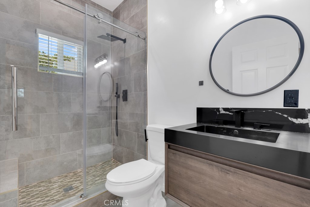 19104 Blackhawk Street Porter Ranch, CA 91326 - Photo 17 of 30 a bathroom with a sink a toilet and a mirror