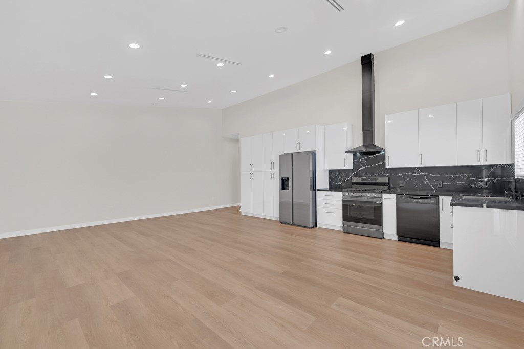 19104 Blackhawk Street Porter Ranch, CA 91326 - Photo 8 of 30 a kitchen with stainless steel appliances kitchen island granite countertop a sink a stove and a refrigerator