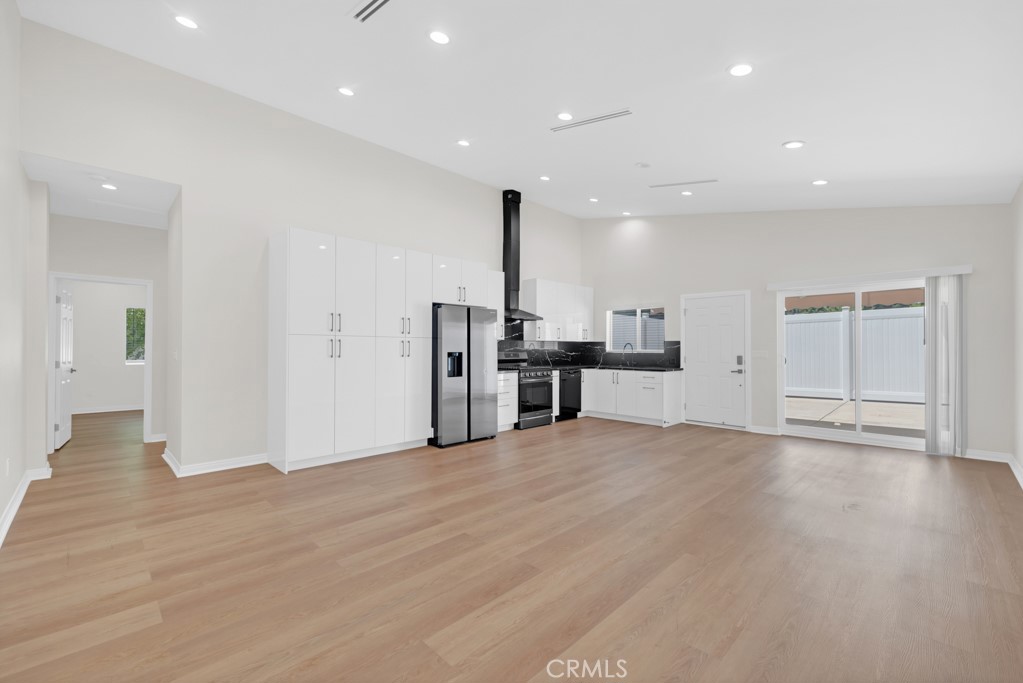 19104 Blackhawk Street Porter Ranch, CA 91326 - Photo 10 of 30 a view of empty room with wooden floor and kitchen