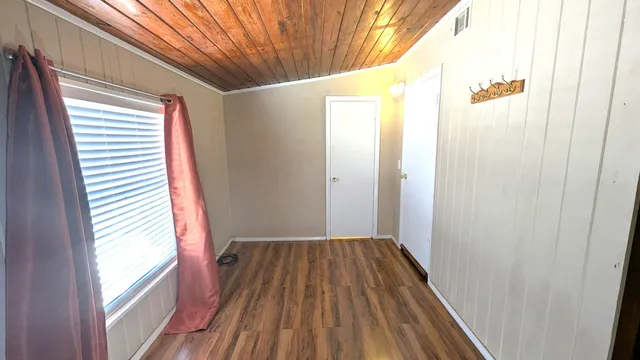 a view of a room with wooden floor and windows