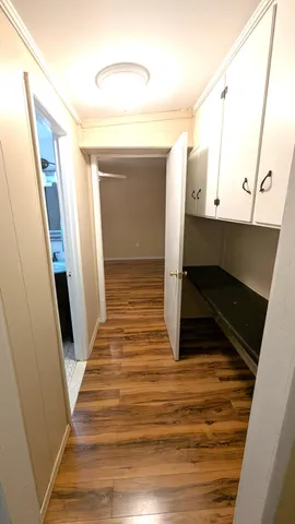 a view of a hallway with wooden floor and staircase