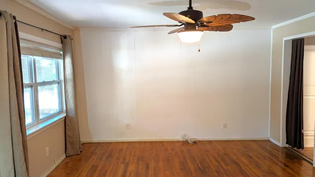 a view of room with hardwood floor and a ceiling fan
