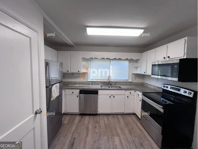 a kitchen with a sink stove top oven and refrigerator