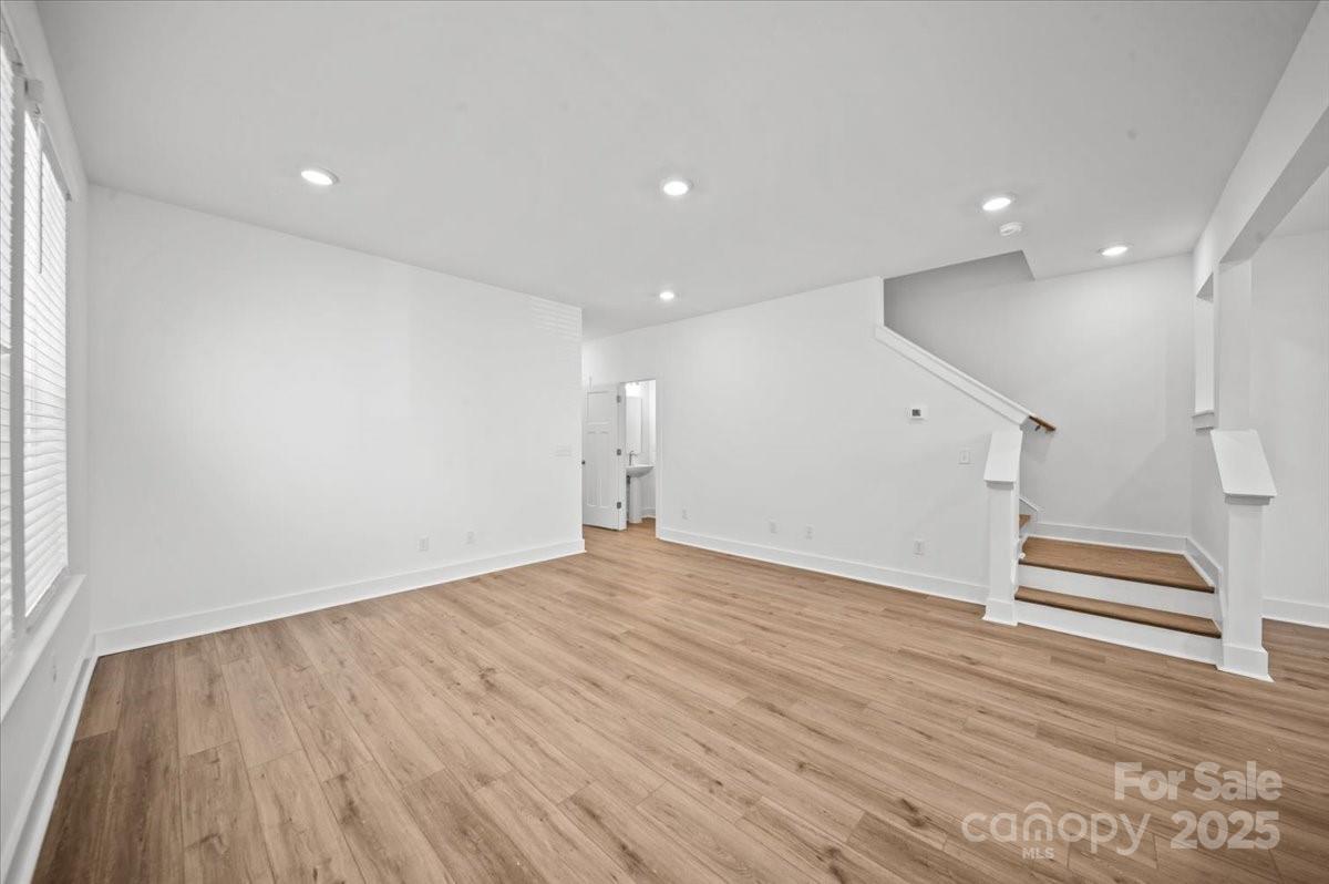 45 Moon Hvn Way Arden, NC 28704 - Photo 11 of 31 an empty room with wooden floor and stairs