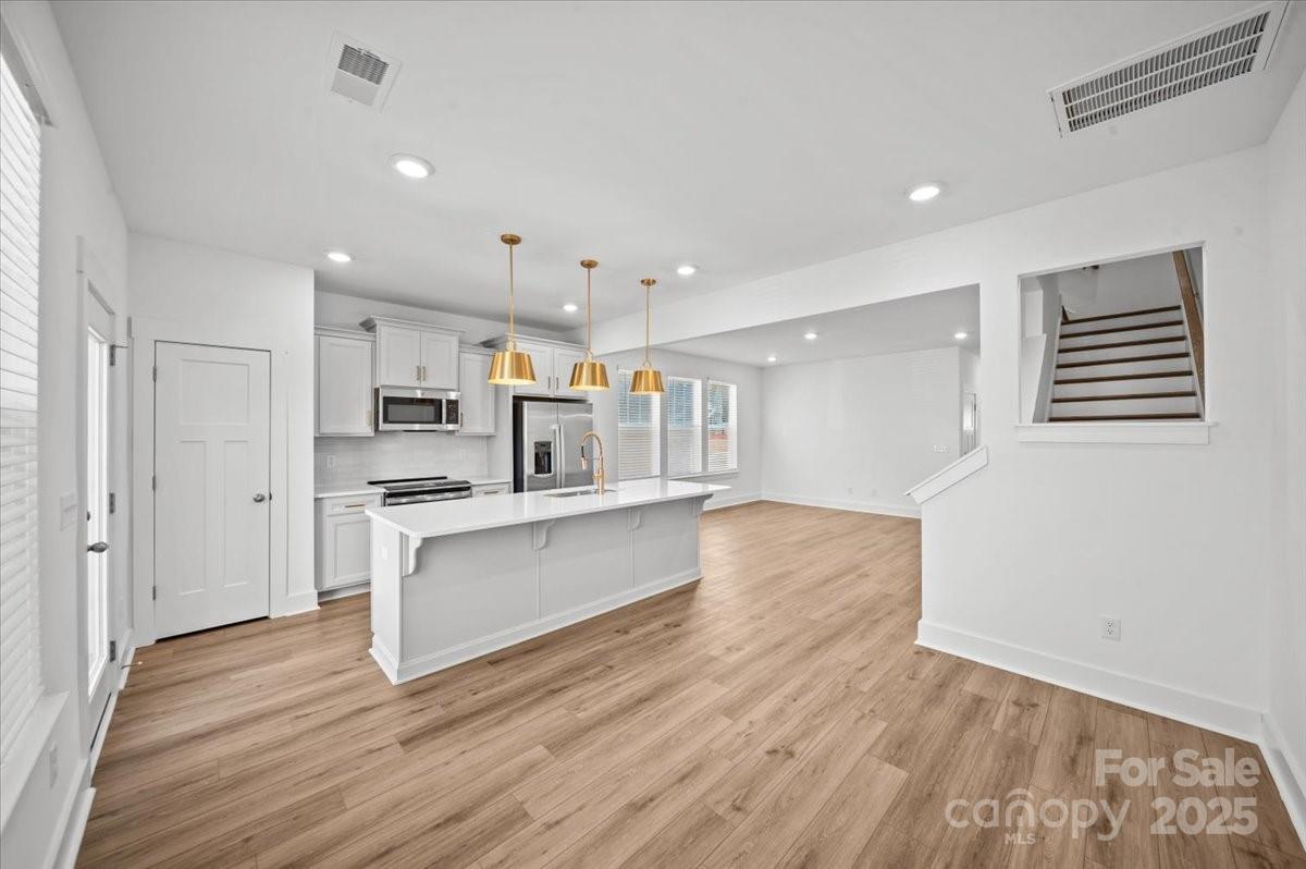 45 Moon Hvn Way Arden, NC 28704 - Photo 3 of 31 a large kitchen with stainless steel appliances a large counter top a stove a sink dishwasher and a refrigerator with wooden floor