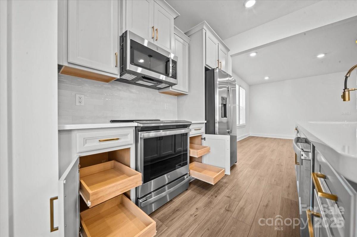 45 Moon Hvn Way Arden, NC 28704 - Photo 5 of 31 a kitchen with stainless steel appliances a stove microwave and cabinets