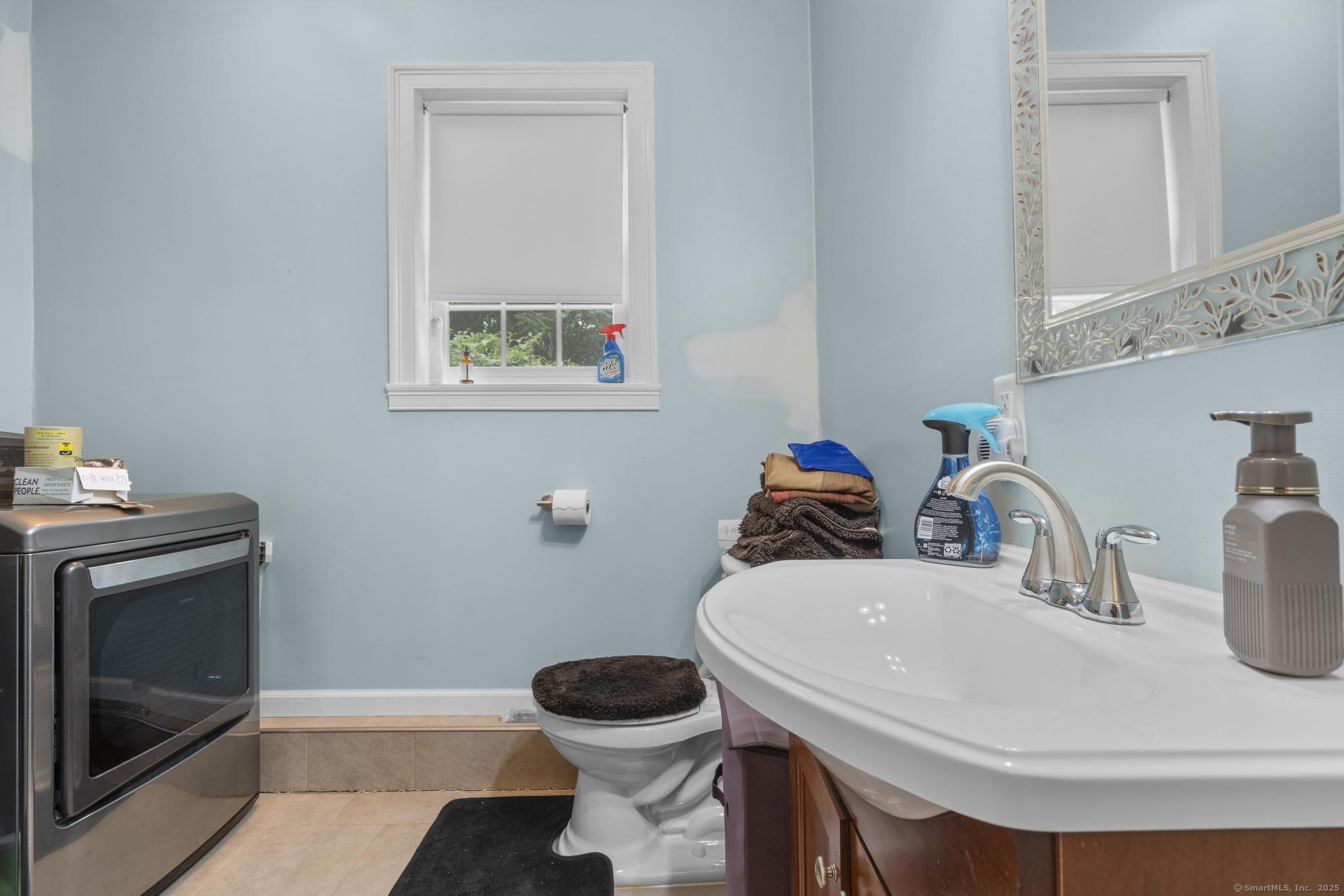 55 Allen Street New Britain, CT 06053 - Photo 12 of 40 a bathroom with a sink a toilet and a mirror