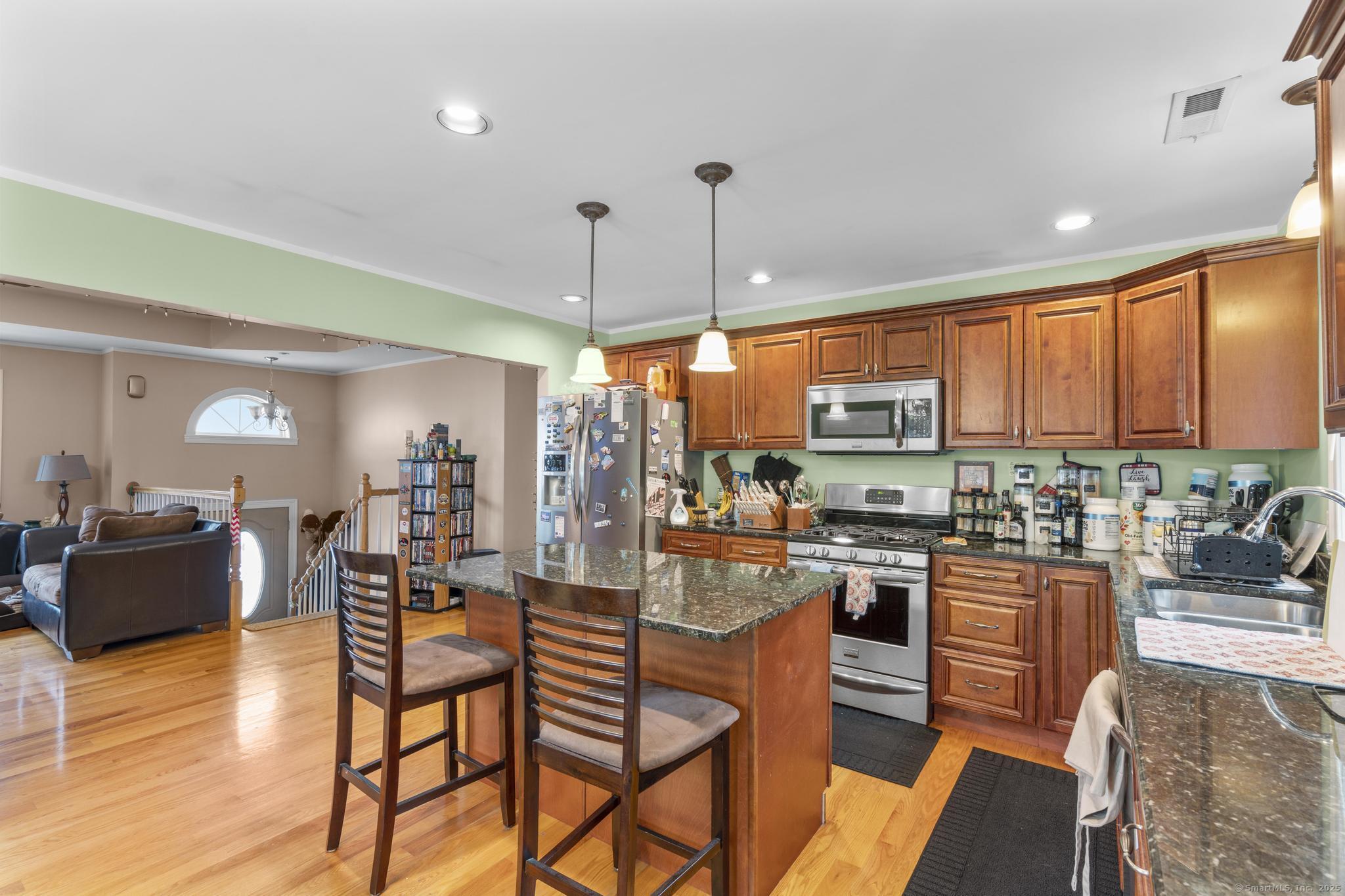 55 Allen Street New Britain, CT 06053 - Photo 25 of 40 a dining hall with stainless steel appliances granite countertop a stove a sink a dining table and chairs with wooden floor