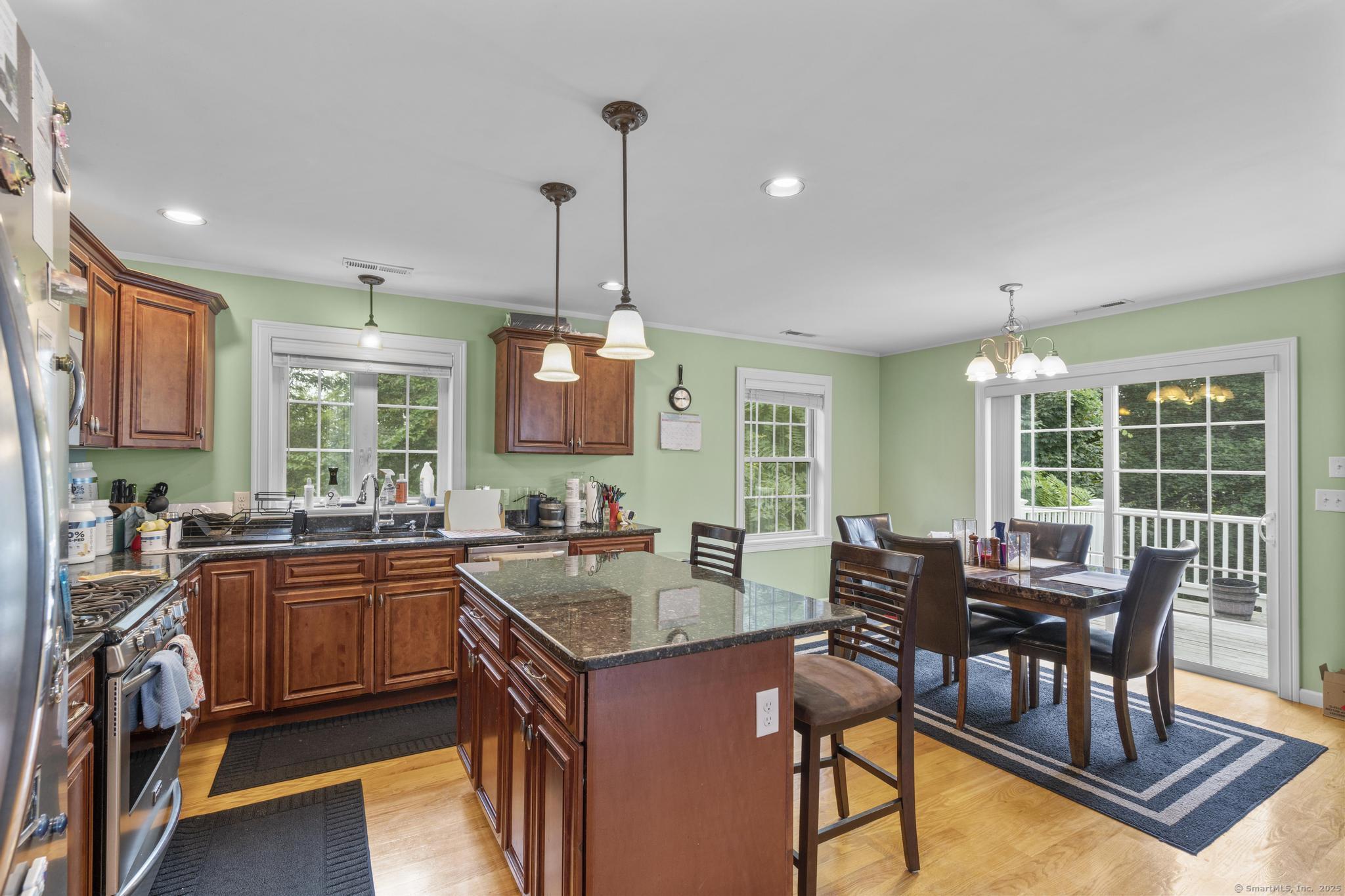 55 Allen Street New Britain, CT 06053 - Photo 27 of 40 a open kitchen with stainless steel appliances granite countertop a stove top oven a sink dishwasher a dining table and chairs with wooden floor