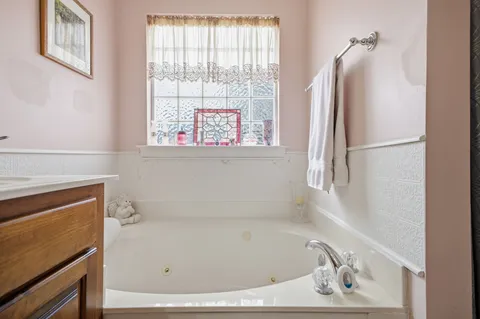 a bedroom with a bed a chair and a chandelier