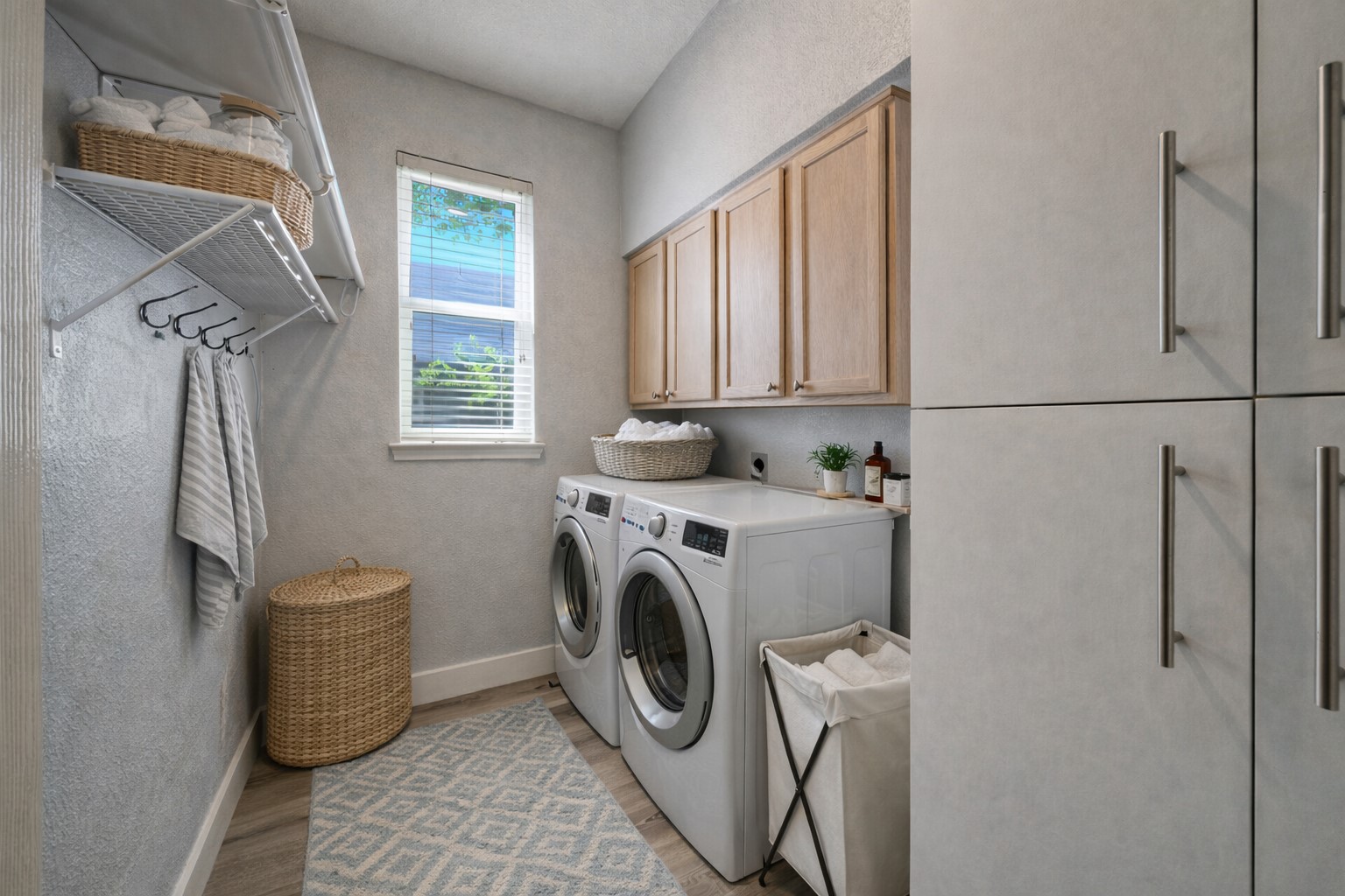 4518 Tello Path Austin, TX 78749 - Photo 11 of 26 Ai - Main Level Laundry room with cabinet space, light wood-style floors, separate washer and dryer, and a textured wall