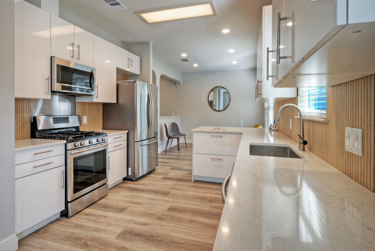 4518 Tello Path Austin, TX 78749 - Photo 8 of 26 Kitchen with stainless steel appliances, white cabinets, light wood-style floors, light stone counters, and modern cabinets