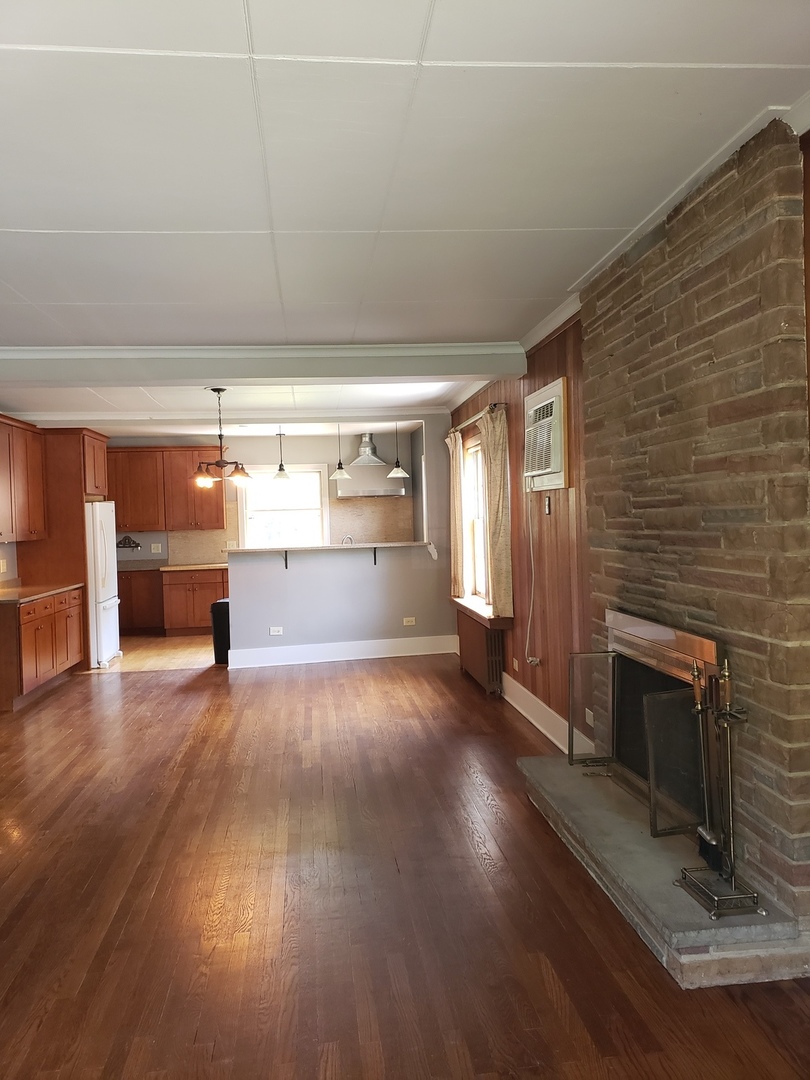 1917 Cedar Road Homewood, IL 60430 - Photo 4 of 20 a view of empty room with wooden floor and fireplace