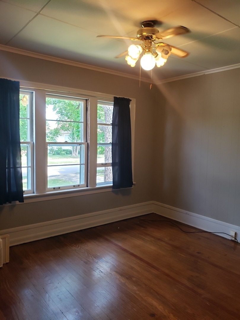 1917 Cedar Road Homewood, IL 60430 - Photo 8 of 20 a view of an empty room with wooden floor and a window