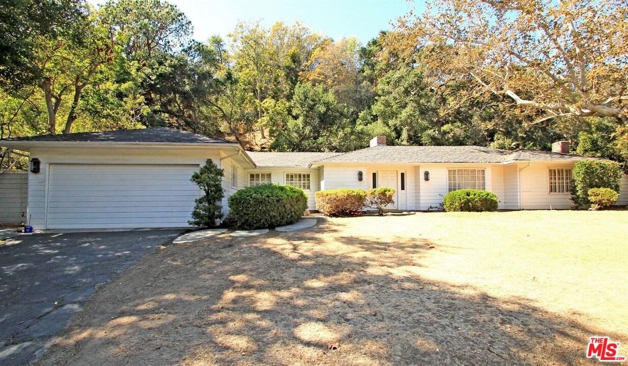 1075 Moraga Drive Los Angeles, CA 90049 - Photo 1 of 3 a view of a house with a yard and tree s
