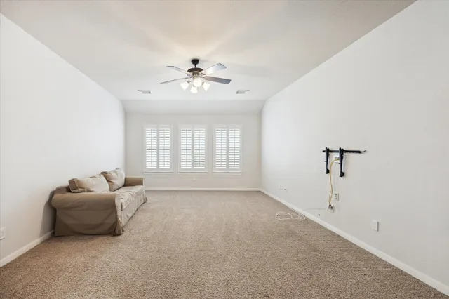 a living room with furniture and a ceiling fan