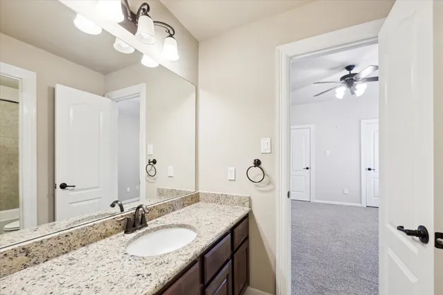 a bathroom with a granite countertop sink a light fixture and a mirror
