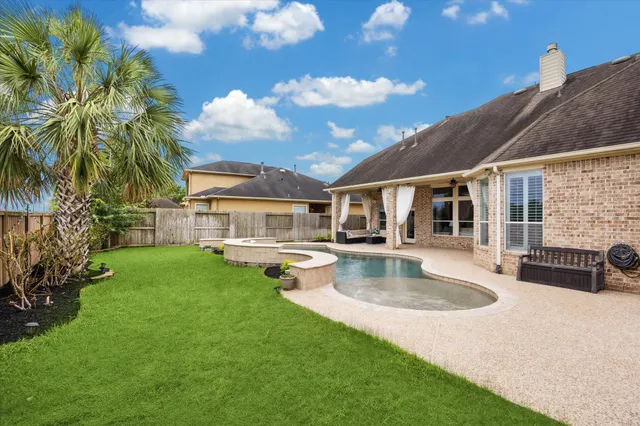 a view of a house with swimming pool and sitting area