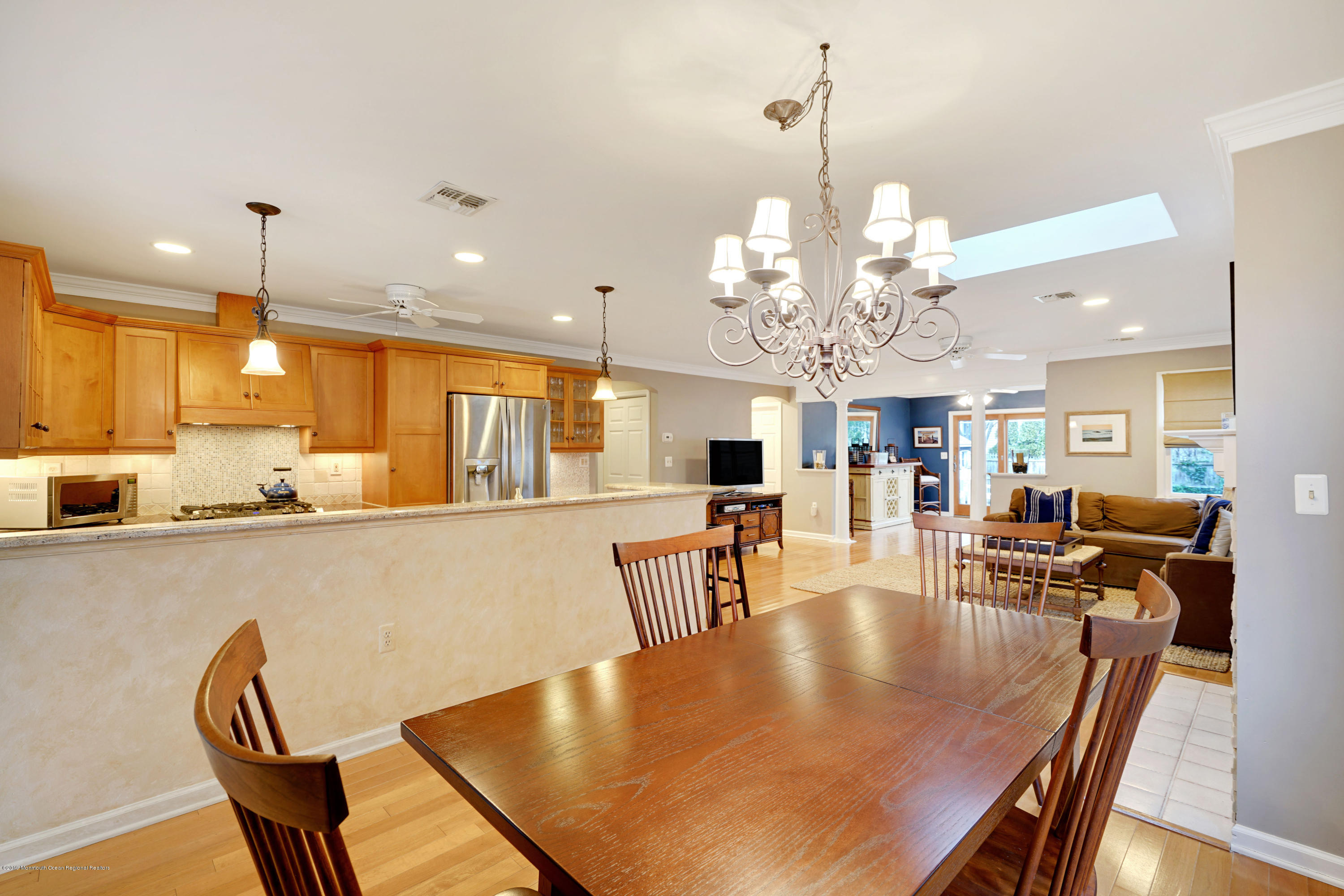1846 Fernwood Road Lake Como, NJ 07719 - Photo 5 of 34 a dining room with wooden floor a chandelier a wooden table and chairs