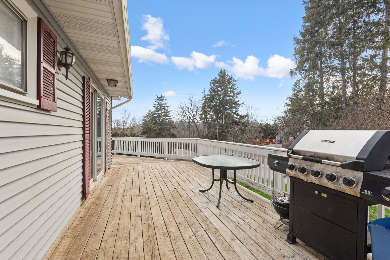 8314 Riverway Drive Cary, IL 60013 - Photo 2 of 12 a view of a roof deck with table and chairs a barbeque with wooden floor and fence