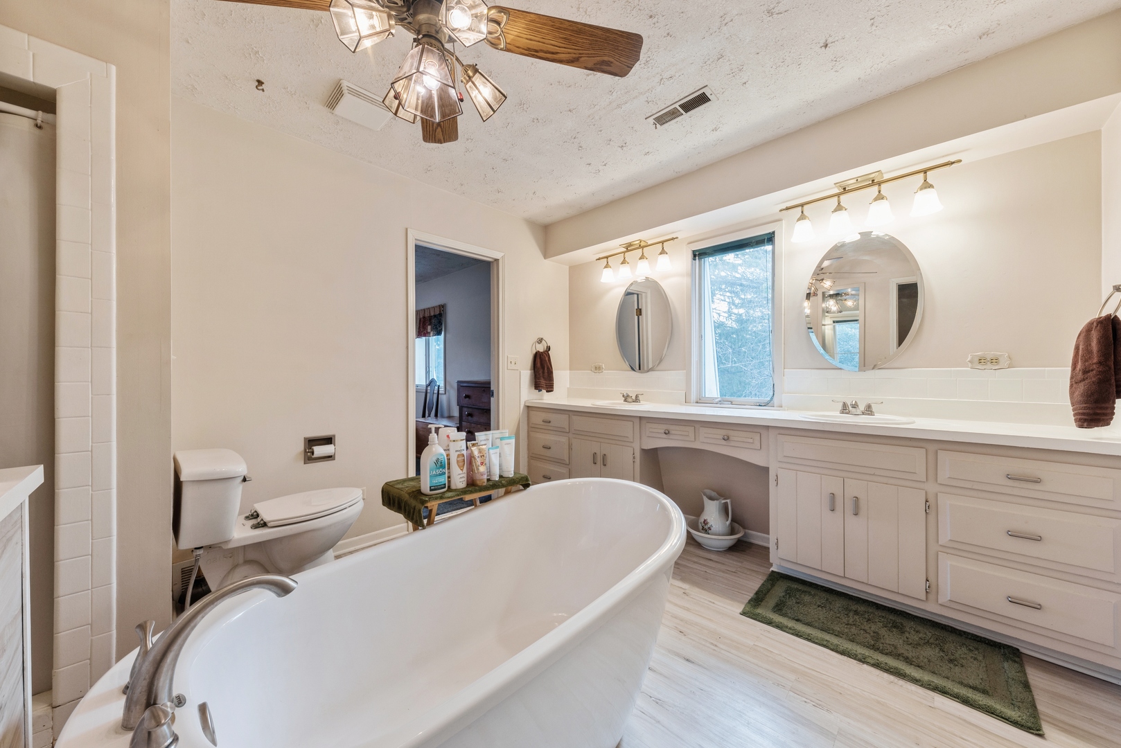 8314 Riverway Drive Cary, IL 60013 - Photo 8 of 12 a spacious bathroom with a double vanity sink a mirror a bathtub and a window