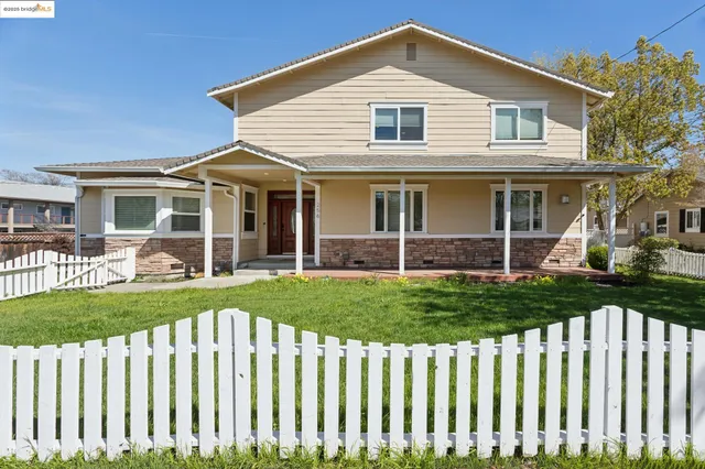 a front view of a house with a garden and plants
