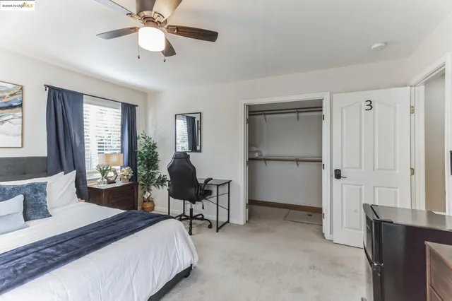 a spacious bedroom with a bed a table and chair