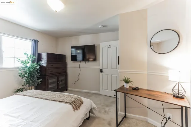 a bedroom with a large bed and a window