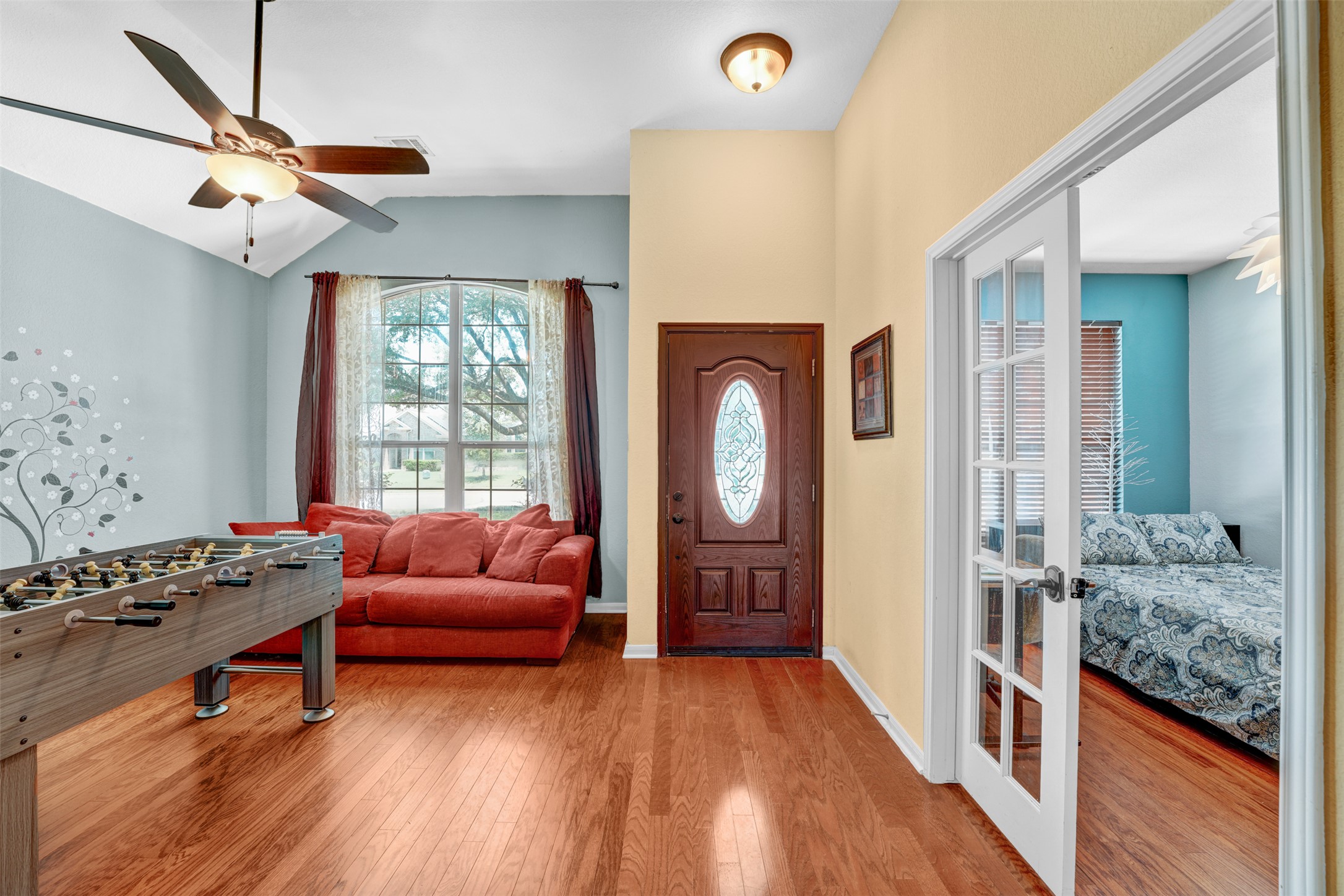 2521 Amen Corner Road Pflugerville, TX 78660 - Photo 15 of 40 Entryway featuring wood-finish flooring, a decorative glass-paneled front door, and a vaulted ceiling with a ceiling fan
