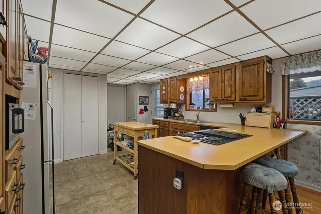 a kitchen that has a table chairs and a refrigerator