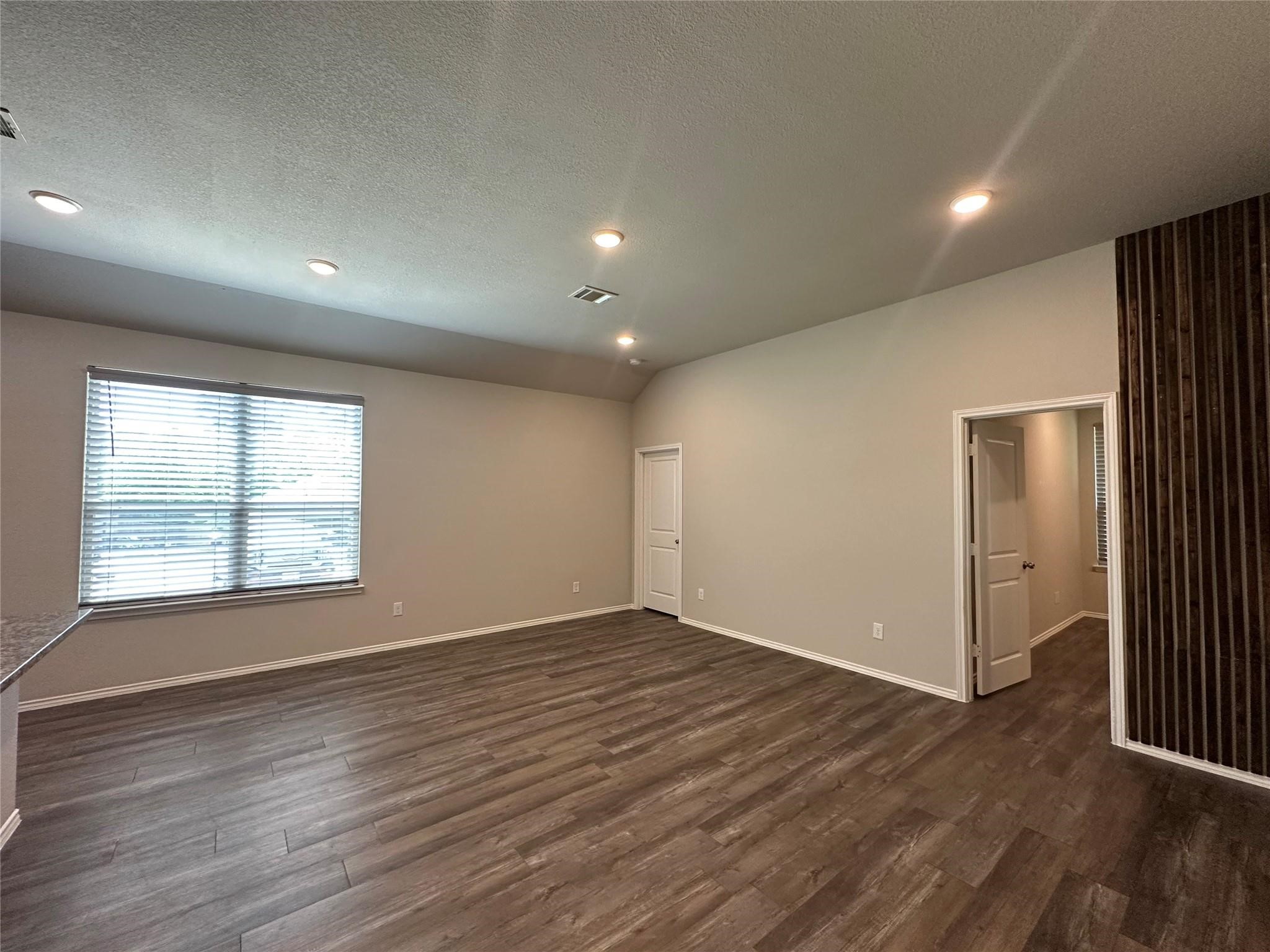 15063 Arrowhead Loop East Willis, TX 77378 - Photo 2 of 7 an empty room with wooden floor and windows