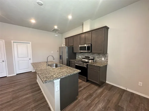 a kitchen with a sink stove and refrigerator