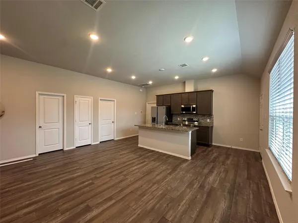 a living room with furniture and a wooden floor