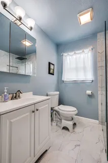 a bathroom with a sink toilet and window