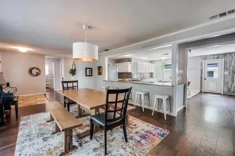 a dining room with a table chairs and a kitchen view