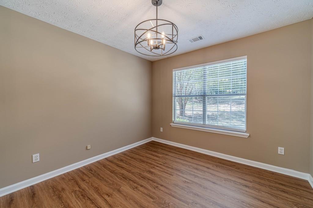 701 Woodland Ridge Drive Monroe, GA 30656 - Photo 11 of 39 a view of an empty room with wooden floor and a window